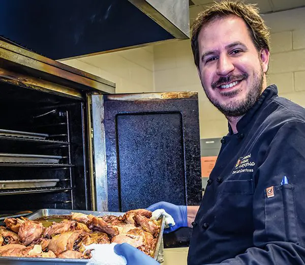 Jeff Zearfoss taking chicken out of the oven