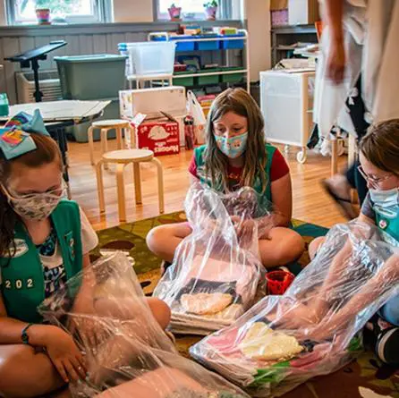 Girl Scouts assembling layettes at FC
